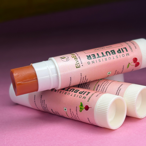 Three lip balm tubes with visible branding on a pink surface