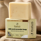 A bar of ElvaEarth Milk and Lavender Soap stacked on its branded box, styled on a stone slab with lavender sprigs, a small bowl, and soft neutral background props.