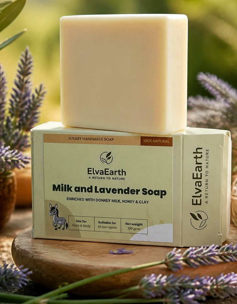 A bar of ElvaEarth Milk and Lavender Soap stacked on its branded retail box, styled on a wooden board with lavender sprigs and a blurred natural outdoor background.